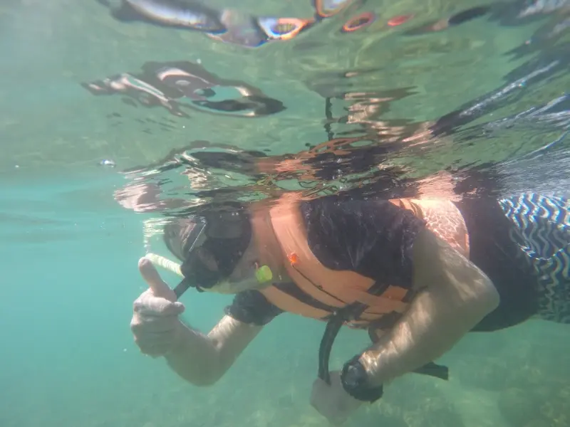 Snorkeler wearing a traditional mask in clear coastal water